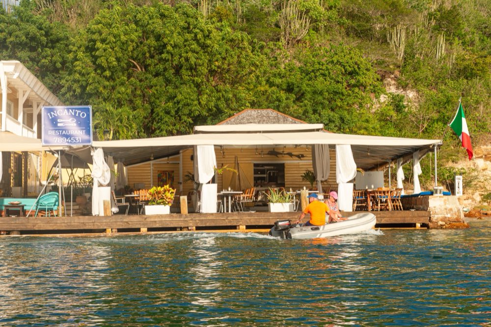 Incanto restaurant on the water at Antigua Slipway, English Harbour, with the dinghy arriving