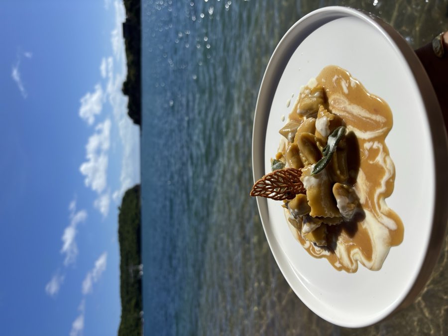 Meat plin ravioli with butter, sage and parmesan cream, served by the sea
